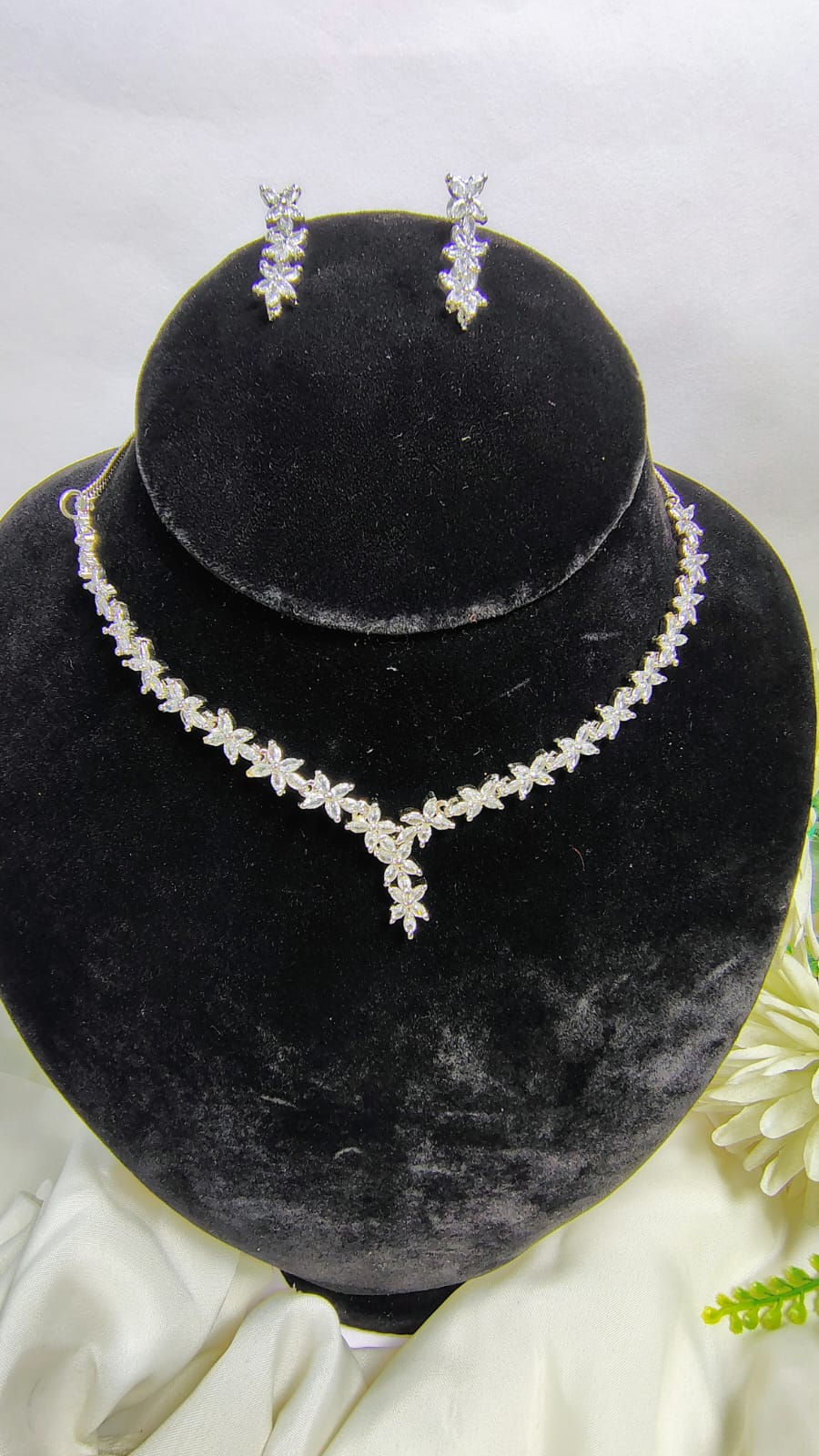 Wincham Fashion House American Diamond leaf necklace set with matching earrings on black display