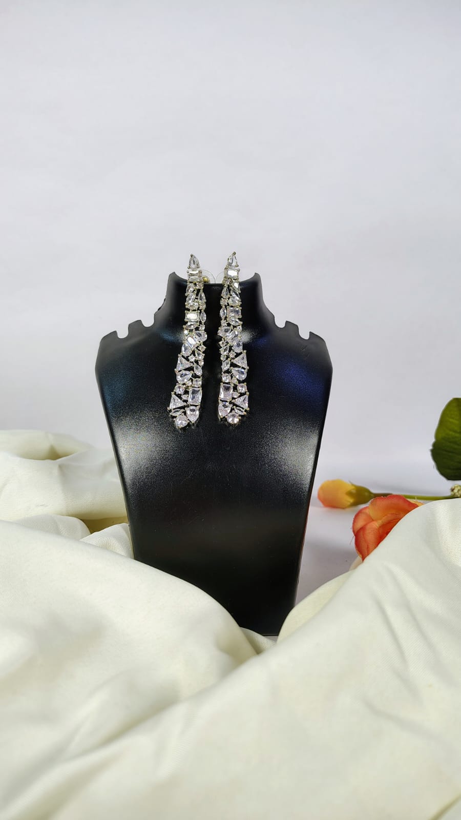 Wincham Fashion House designer American diamond dangle earrings displayed on black stand