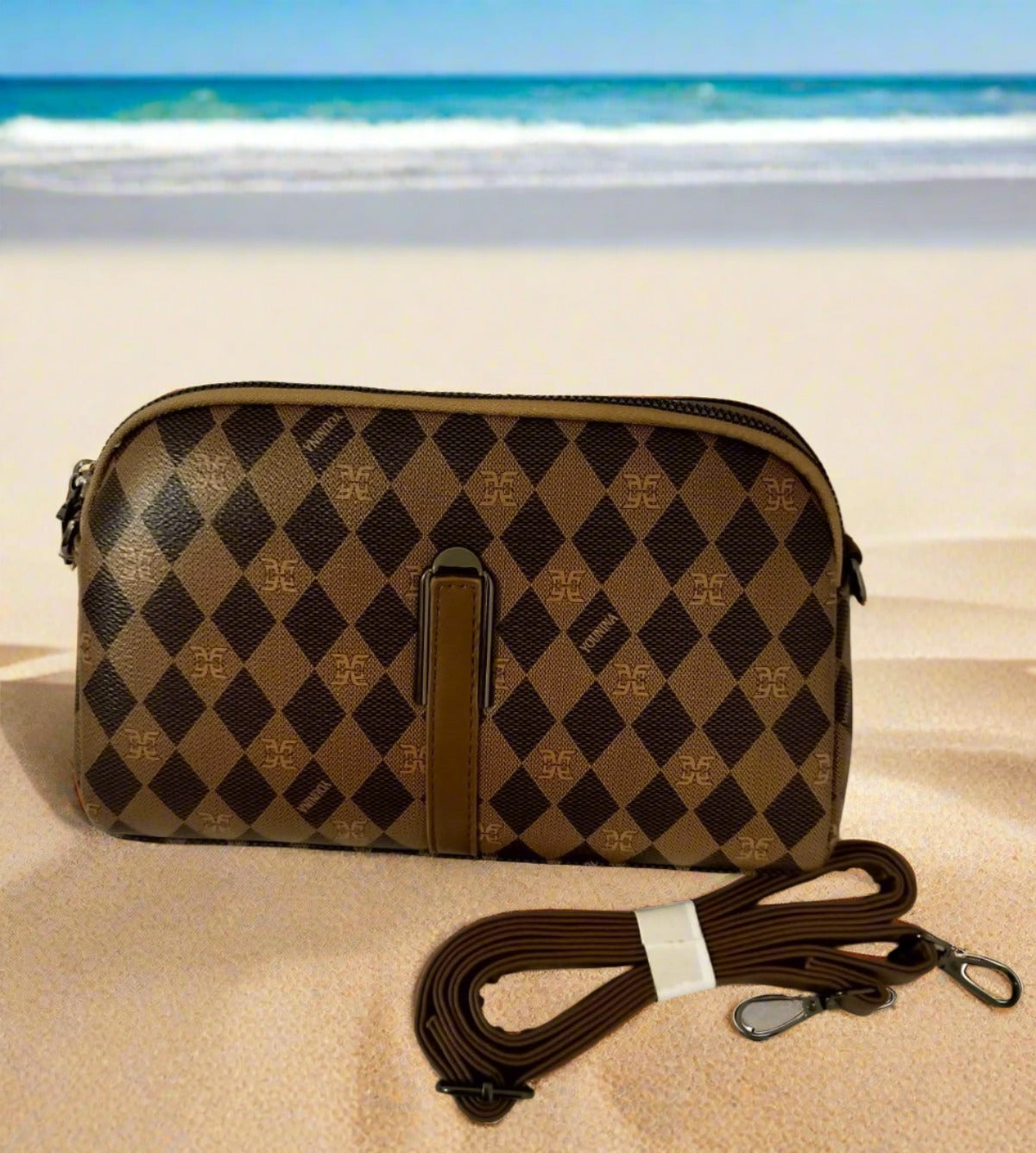 Rust brown handbag for women with diamond pattern and detachable strap shown on sandy beach