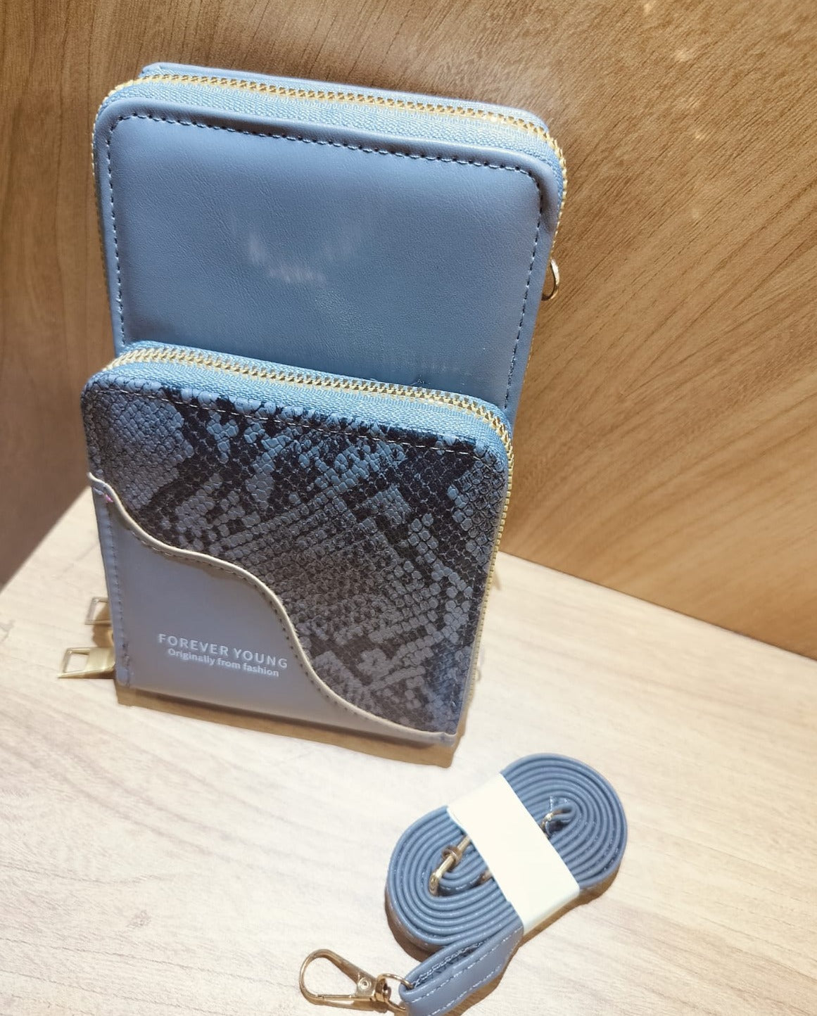 Blue mobile purse sling with snake print front pocket and gold zipper detailing