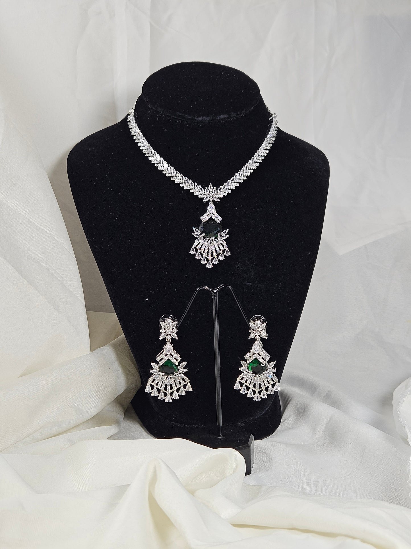 Green AD stone necklace and earring set from Wincham Fashion House displayed on black stand