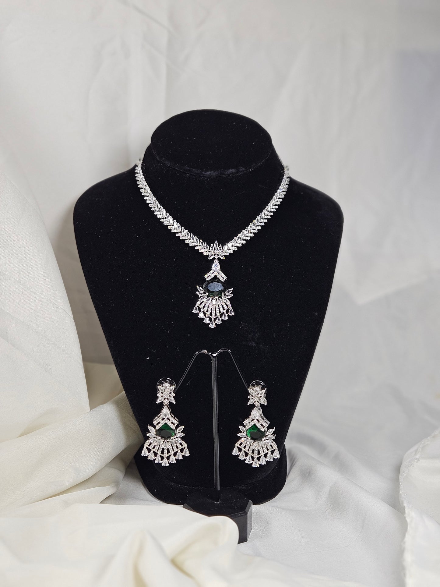 Green AD stone necklace and earring set displayed on black stand from Wincham Fashion House