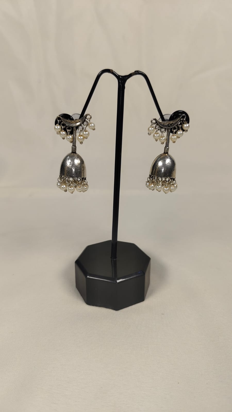Wincham Fashion House pearl drop jhumki earrings alloy silver with intricate pearl detailing on black stand