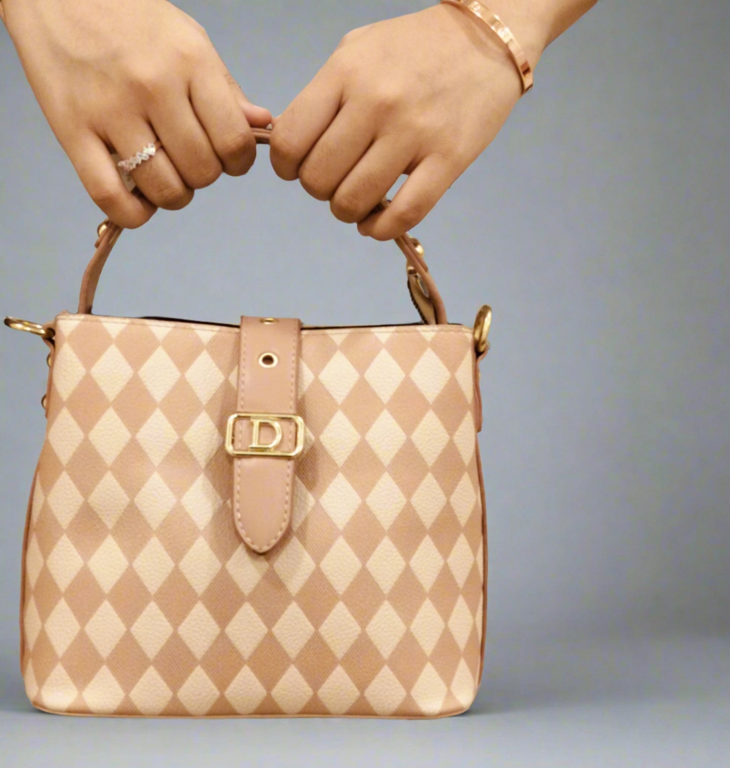 Pink leather purse for women with diamond pattern and gold buckle held by two hands