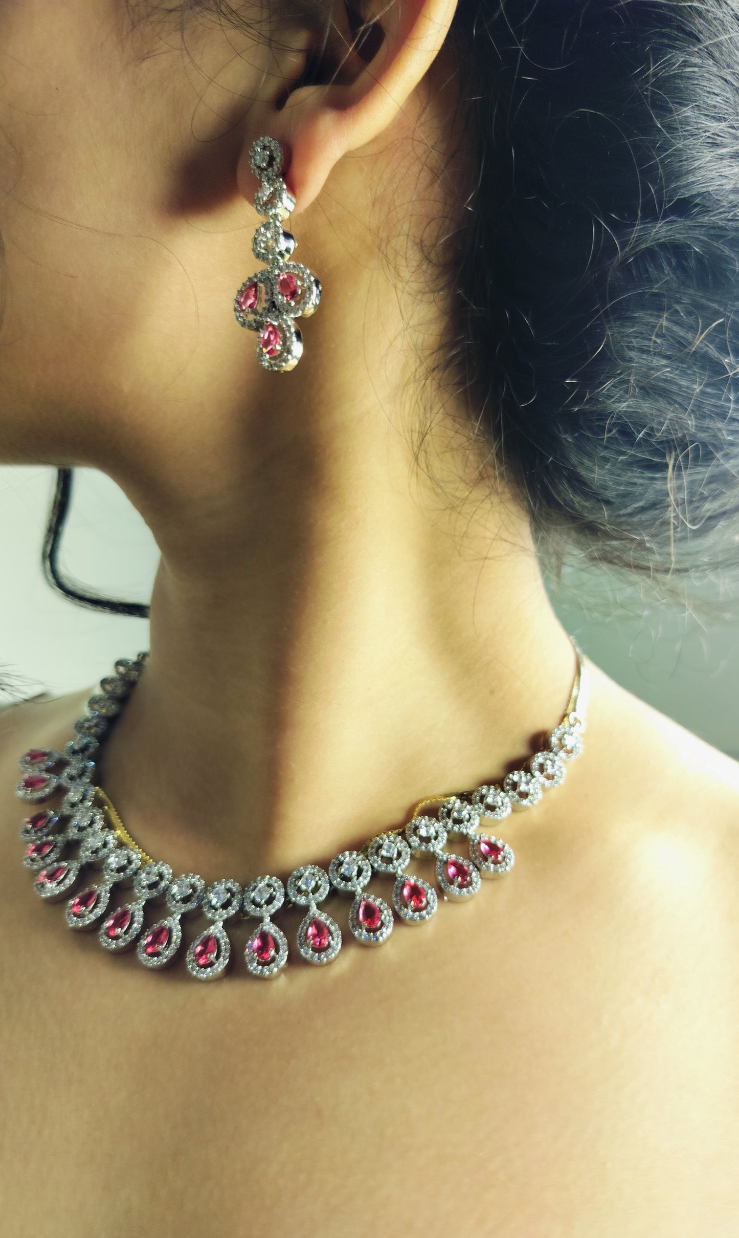 Elegant ruby leaf crystal necklace set with matching earrings worn on neck and ear
