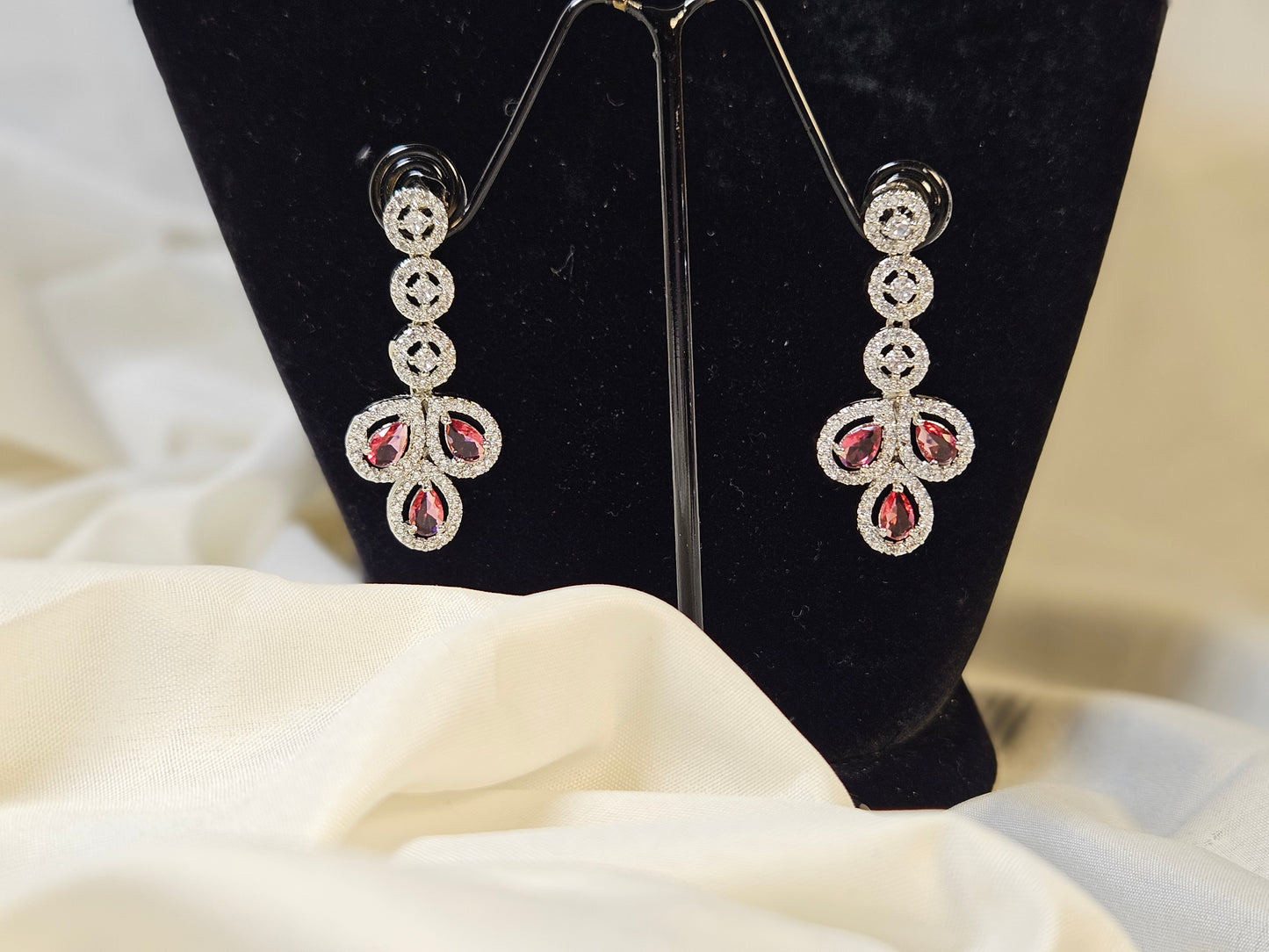 Ruby leaf crystal necklace set earrings with red and clear crystals on black display stand