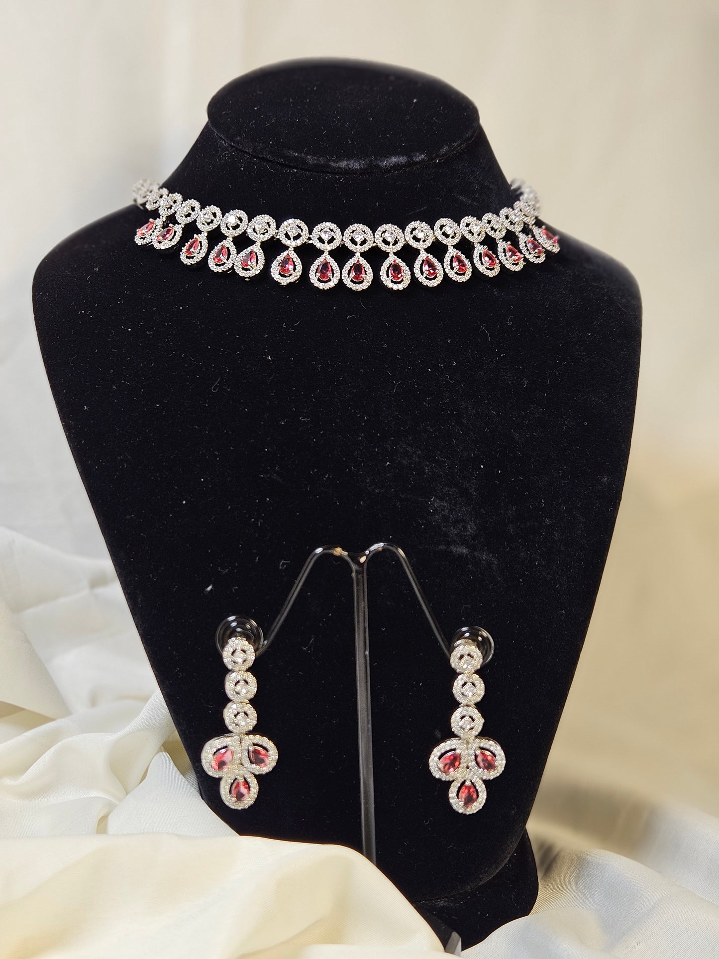 Elegant ruby leaf crystal necklace set with matching earrings displayed