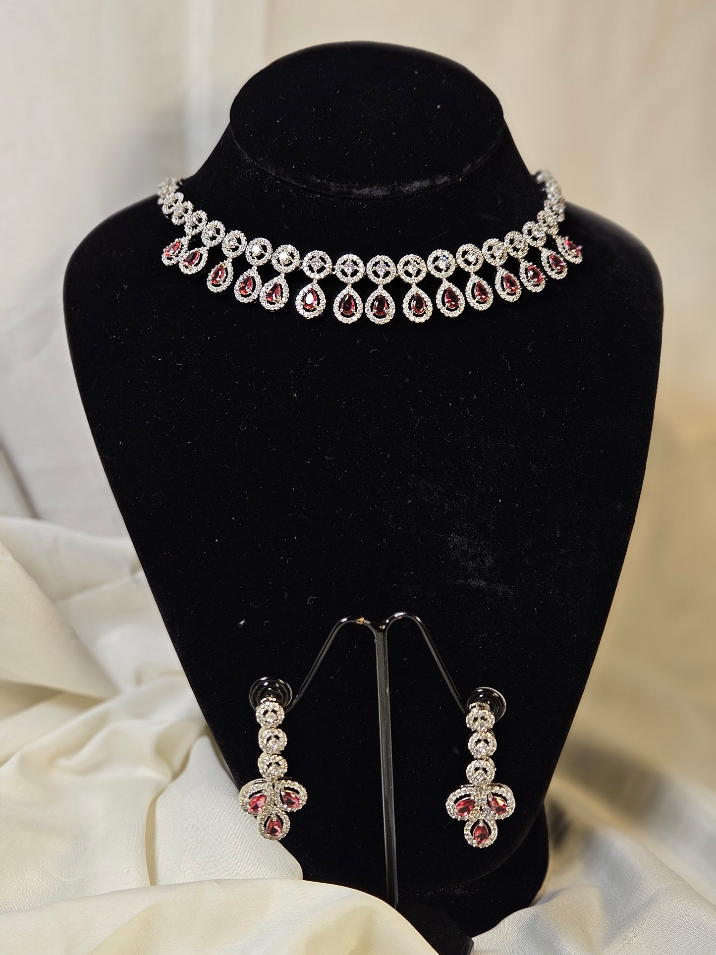 Ruby leaf crystal necklace set featuring a silver necklace and matching earrings with red and clear crystals