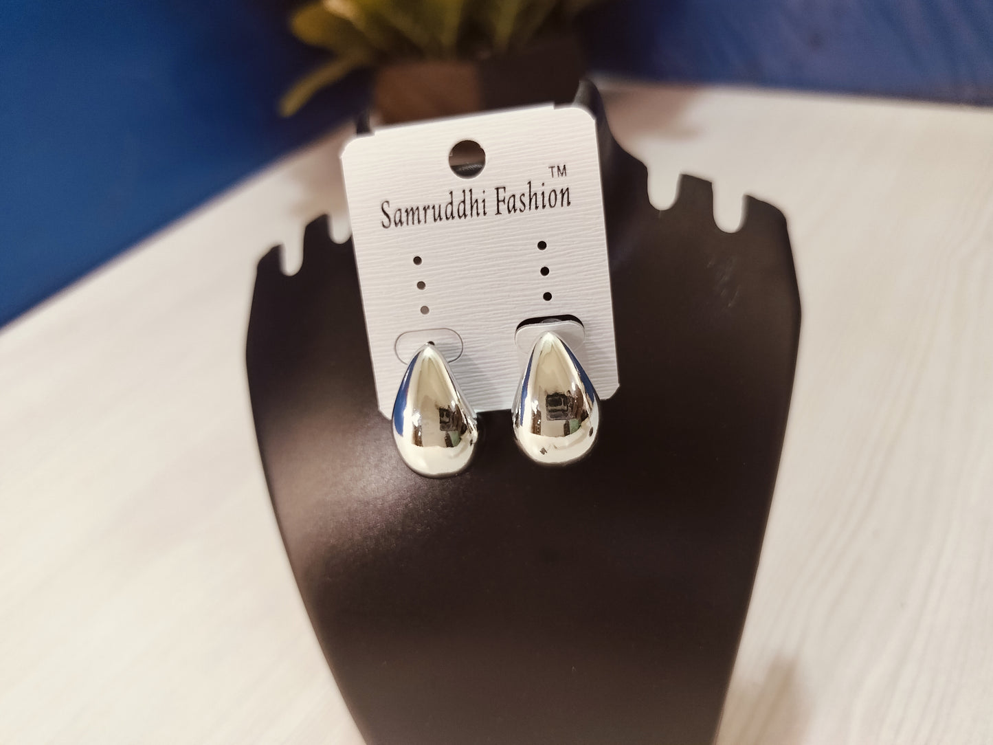 Wincham Fashion House Korean silver hoop earrings displayed on black stand with smooth polished finish