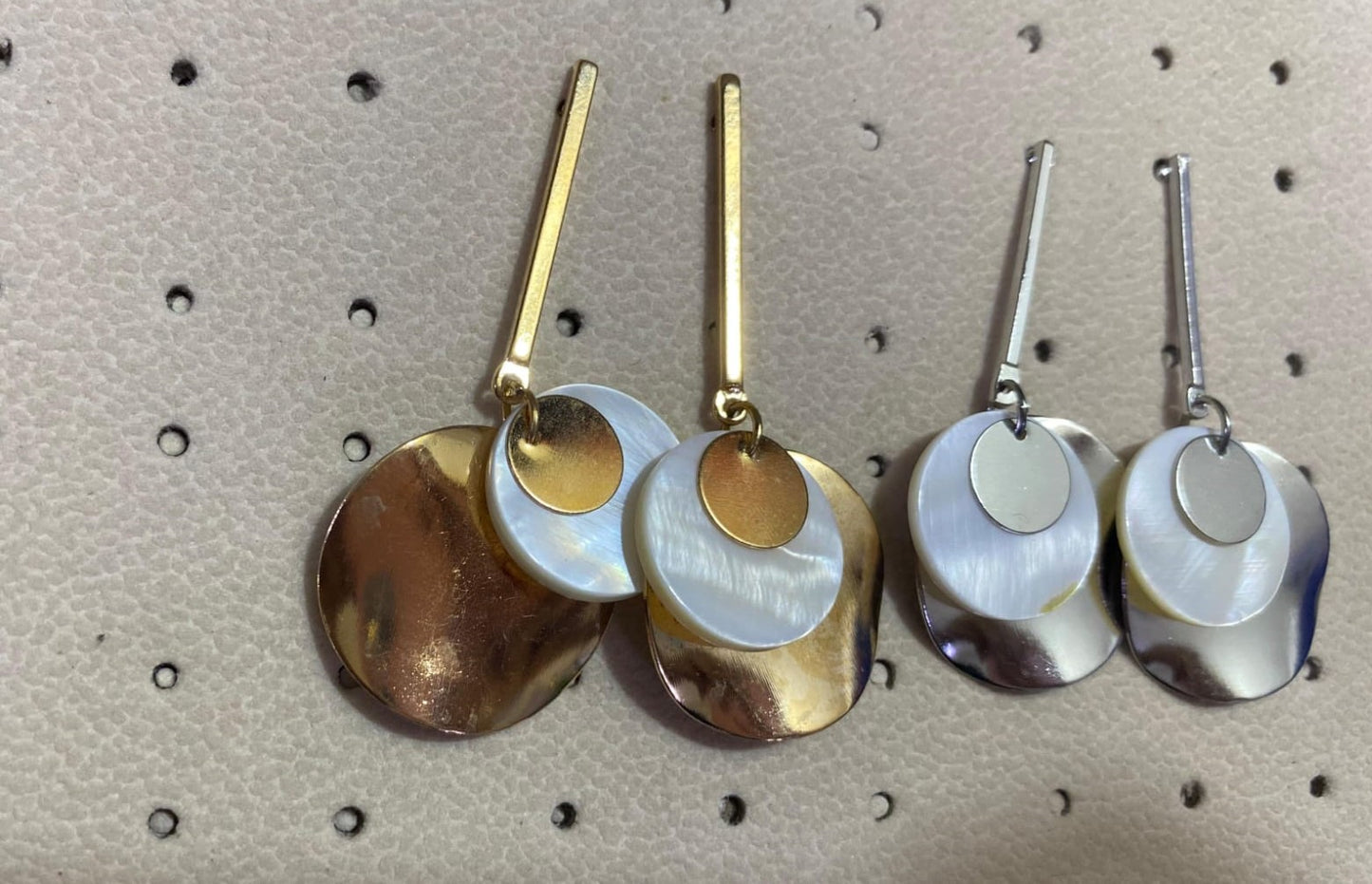 Wincham Fashion House silver and gold seashell earrings with layered circular design on beige background