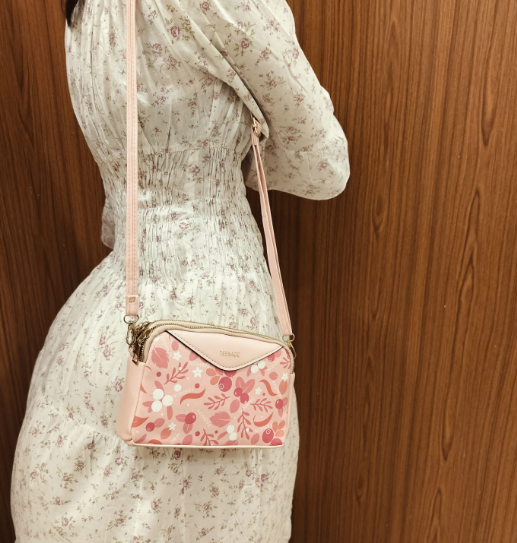 Floral pink crossbody bag for women with adjustable strap worn over white floral dress