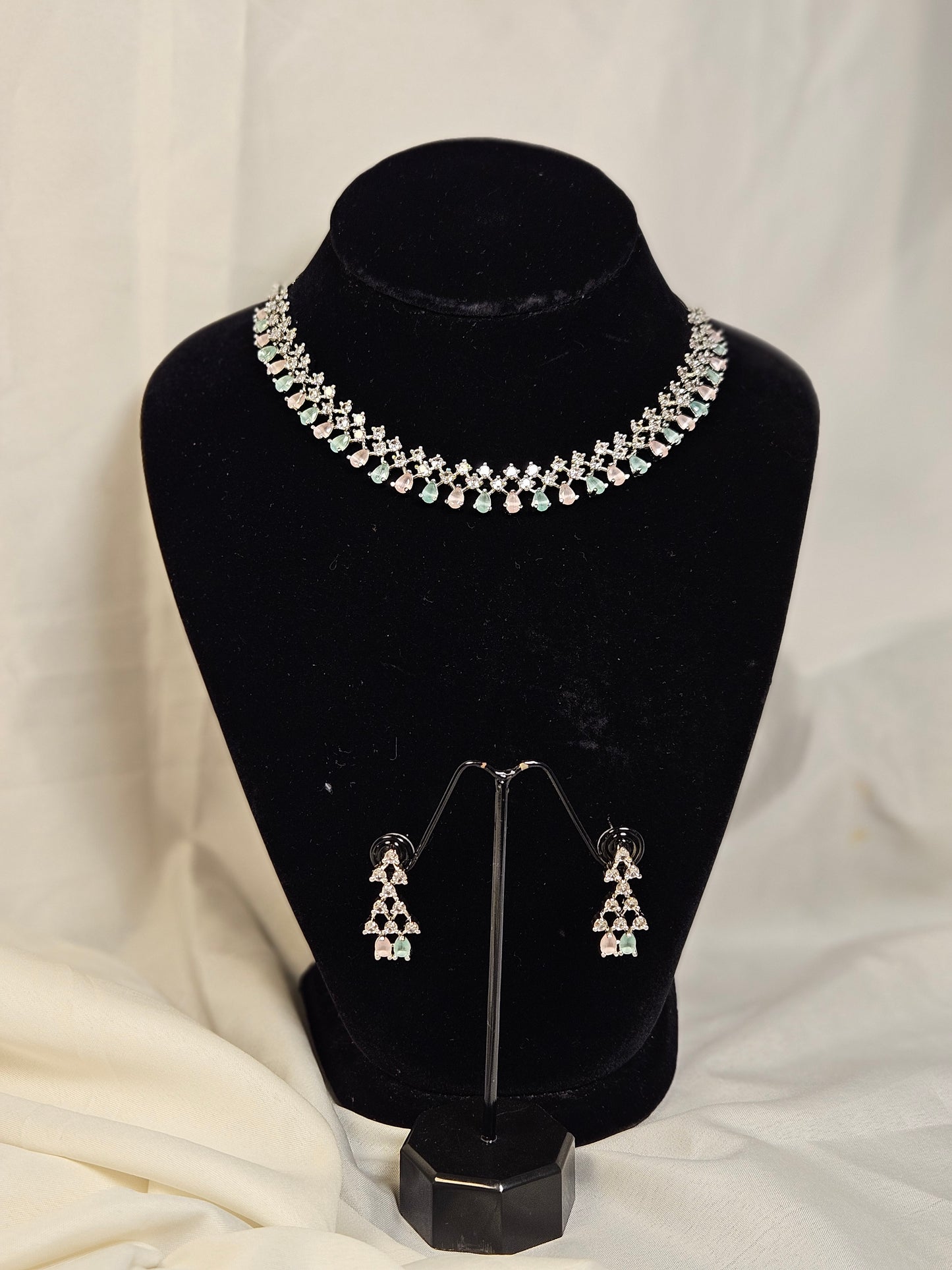 Wincham Fashion House American diamond necklace set with matching earrings on black stand
