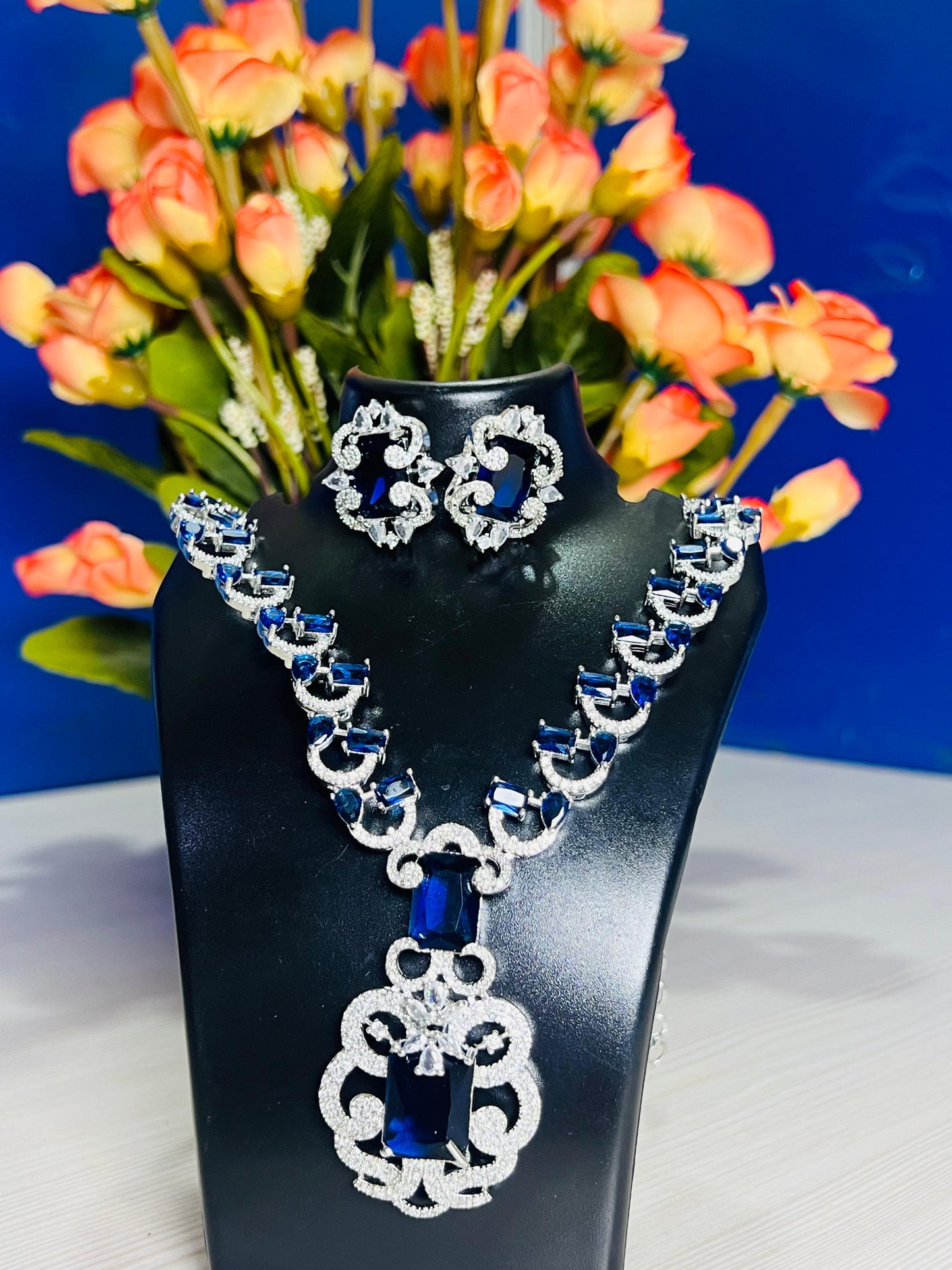 Elite royal blue design necklace set for weddings by Wincham Fashion House displayed on black stand with matching earrings
