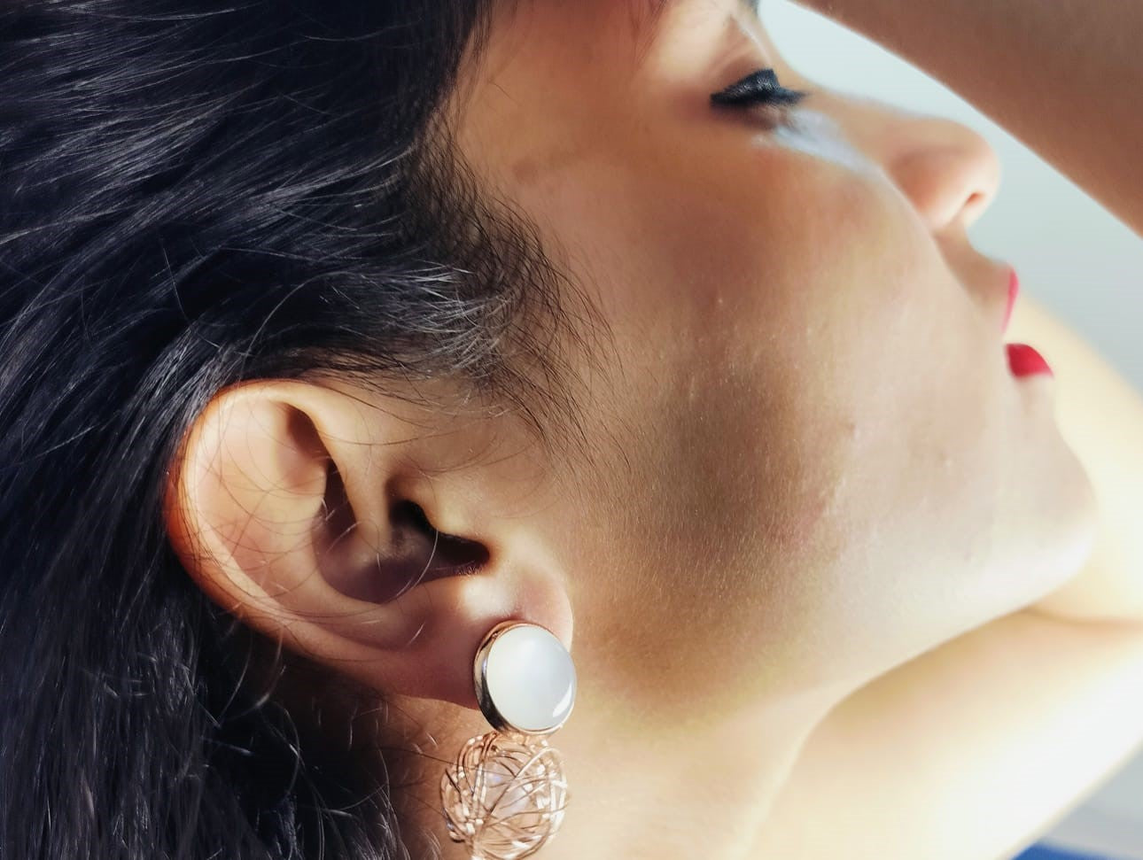 Close-up side profile of a woman wearing Korean pearl gold earrings from Wincham Fashion House