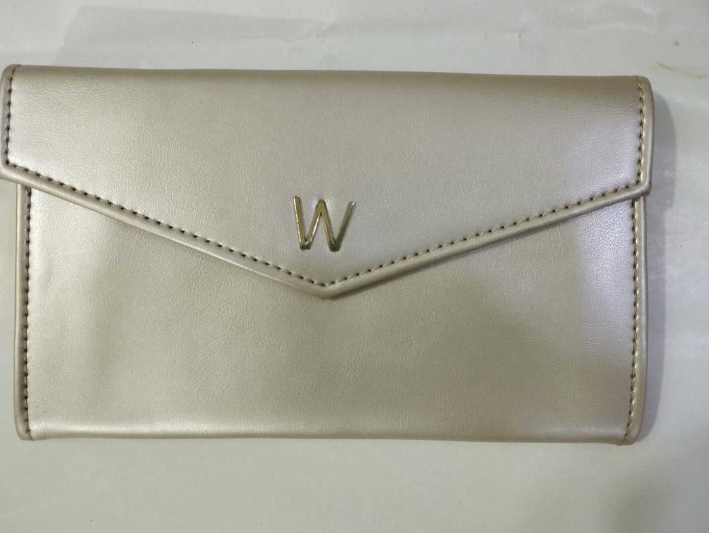 Elegant Wincham Fashion House small hand bag purse in metallic beige with a sleek envelope design