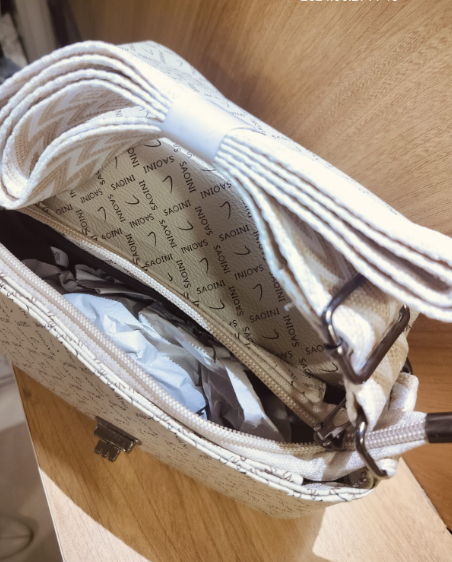 Women's off white crossbody bag with belt featuring spacious interior and branded lining