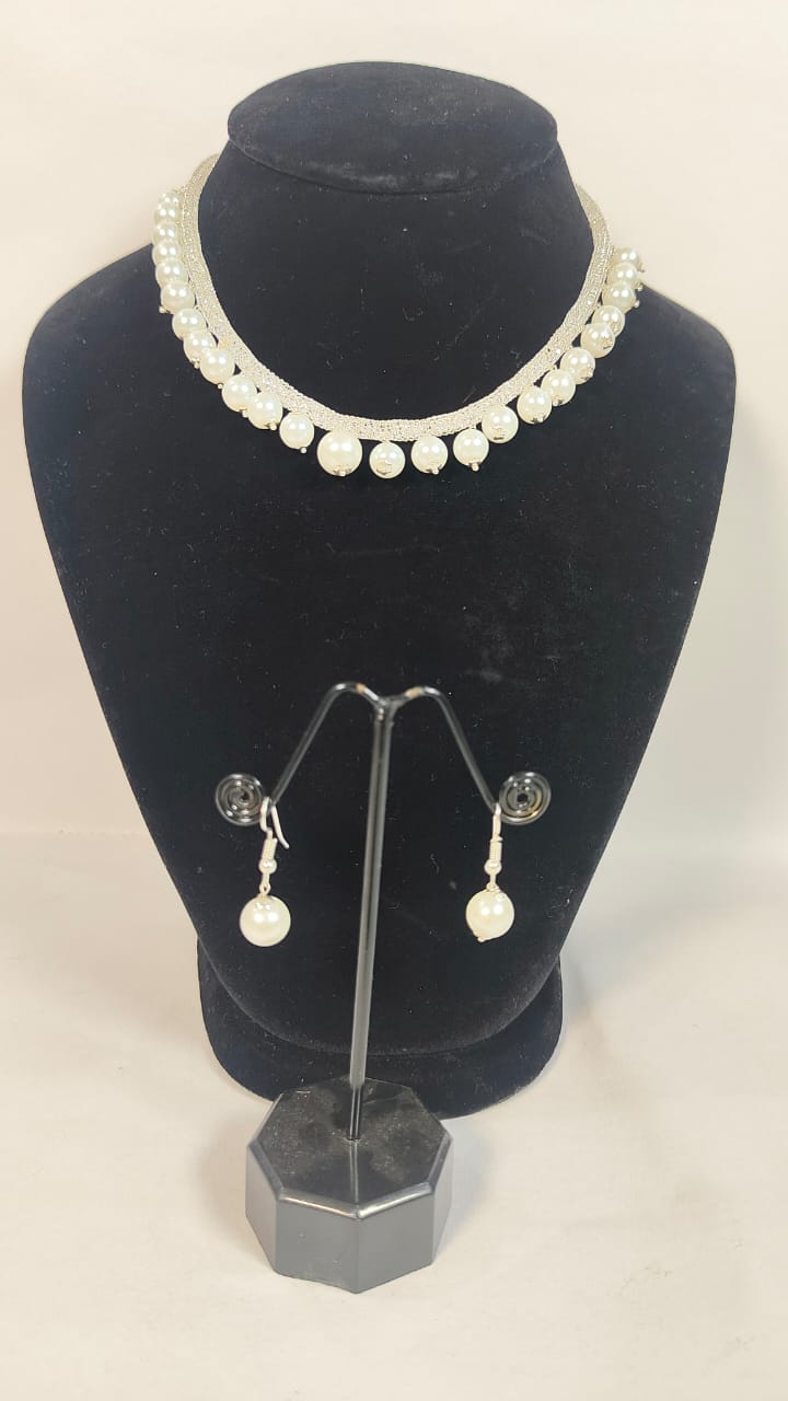 Elegant antique cubic zirconia pearl necklace displayed on a black bust with matching earrings