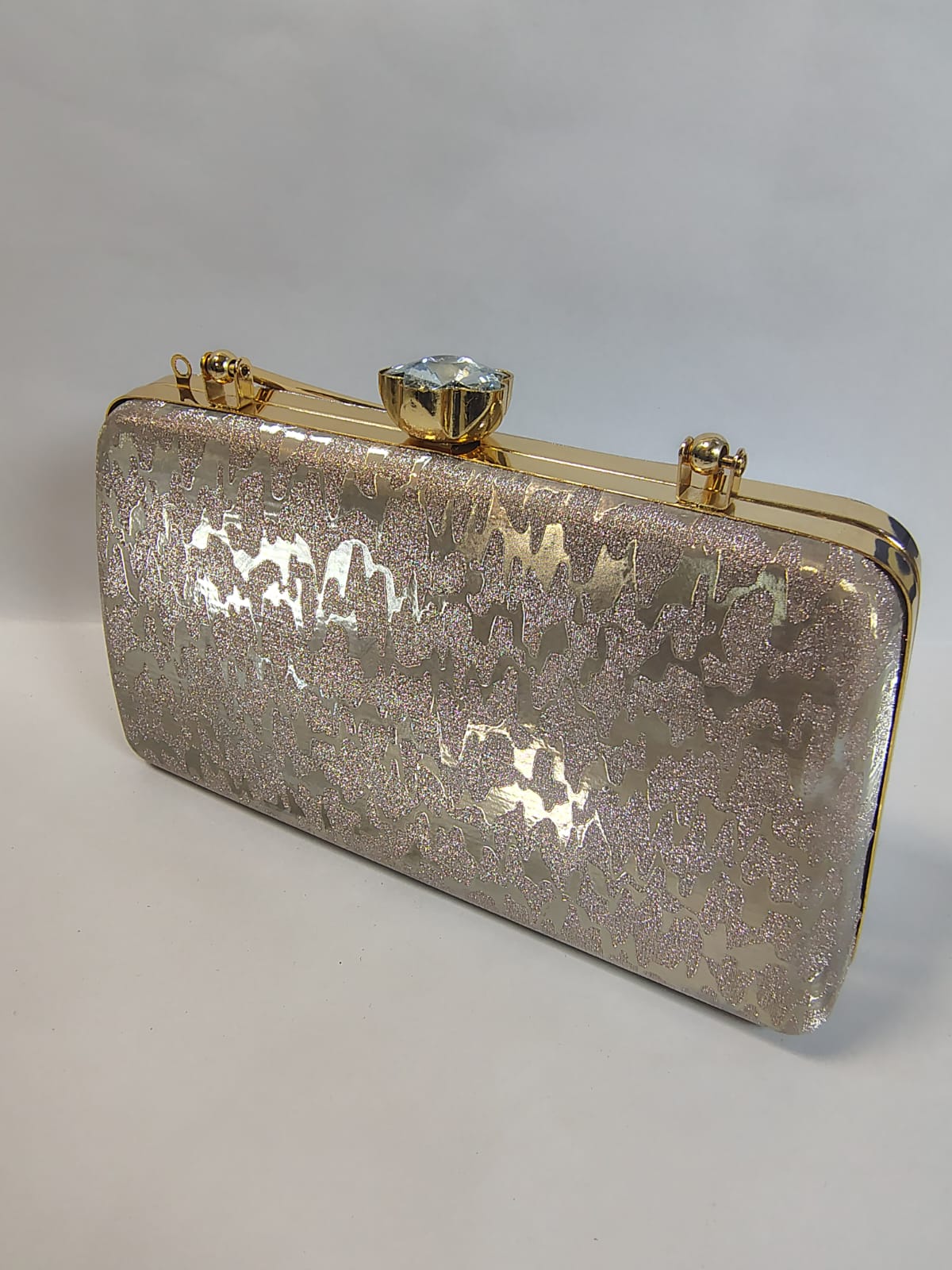 Elegant Wincham Fashion House clutch gold bag with a shimmering finish and crystal clasp closure