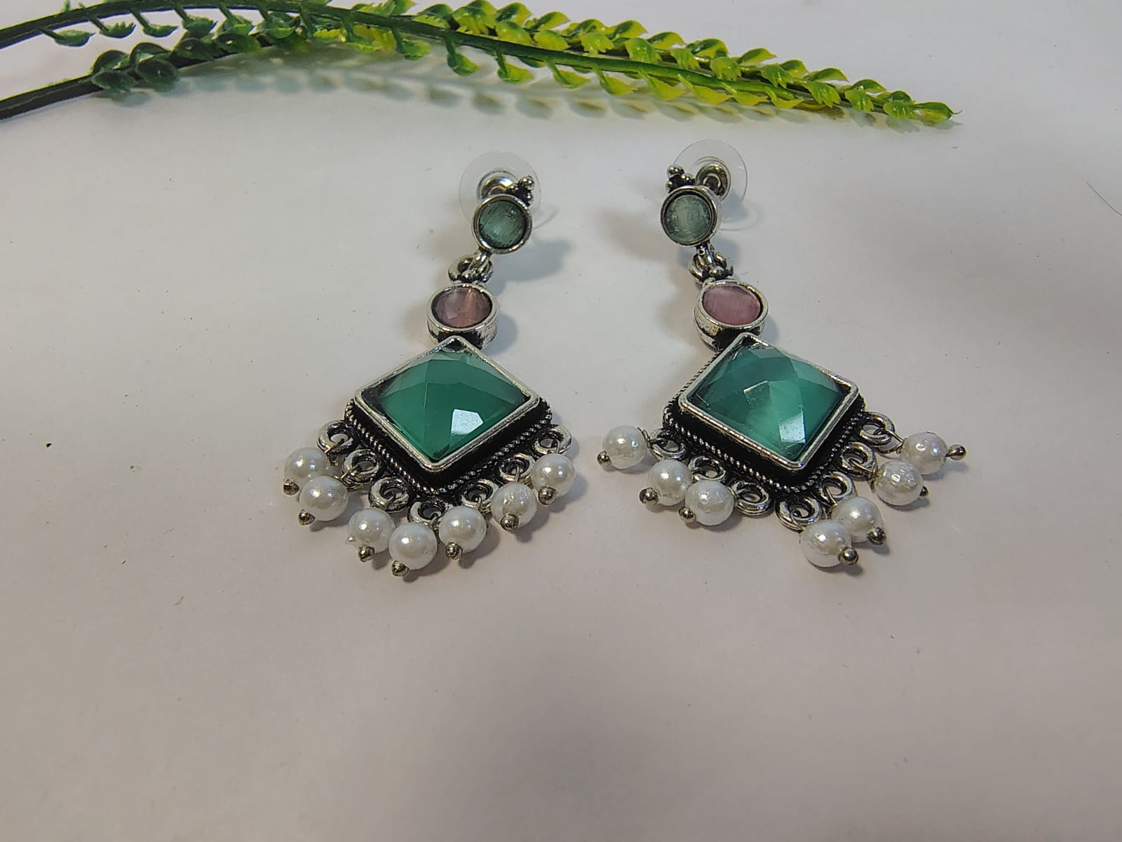 Wincham Fashion House dangle earrings featuring green and purple stones with pearl embellishments