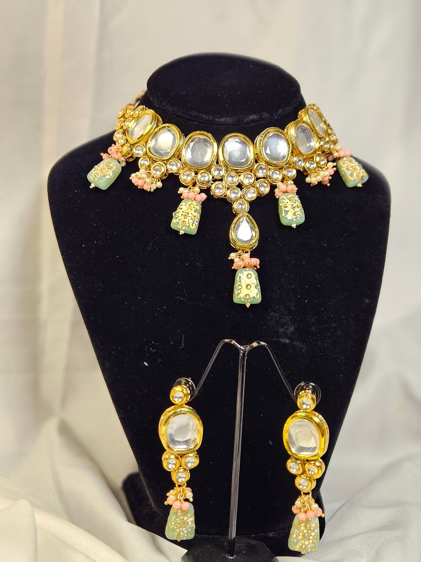 Exquisite Indian jewelry set including a necklace and earrings with intricate gold design and colorful beads