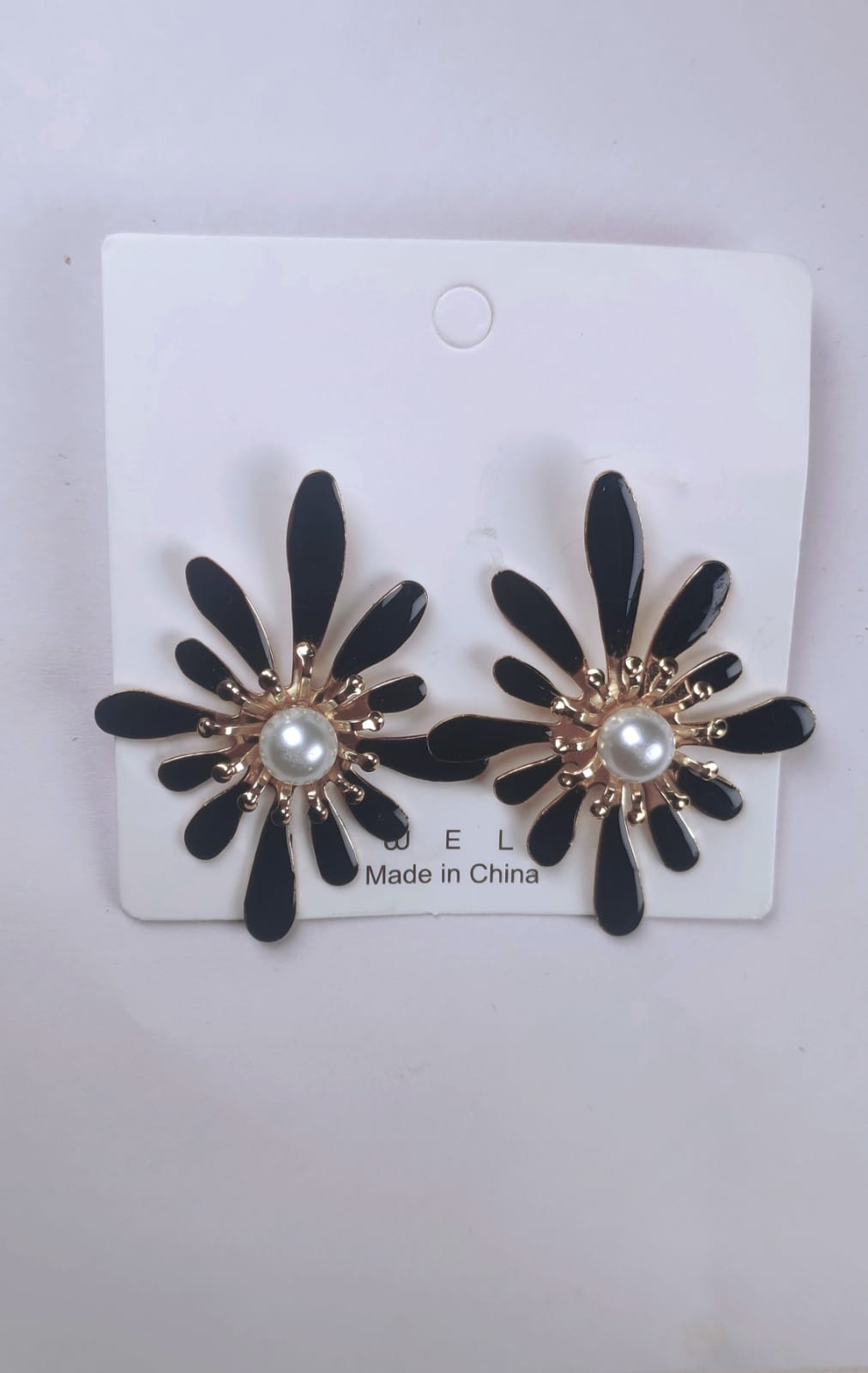 Korean flower earrings with black petals and pearl center displayed on white card