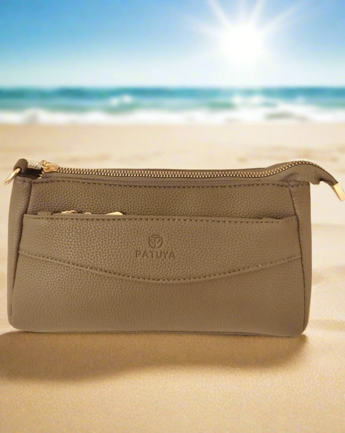 Grey women's crossbody bag grey with front pocket and zipper closure on beach background