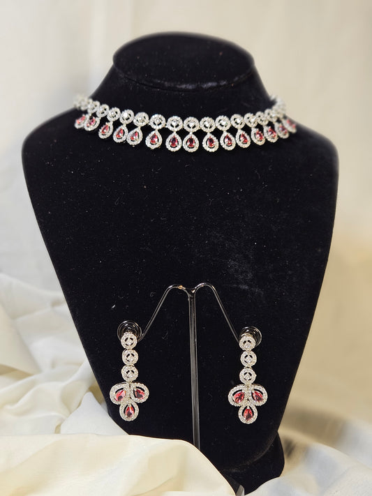 Ruby leaf crystal necklace set with matching earrings displayed on black jewelry stand