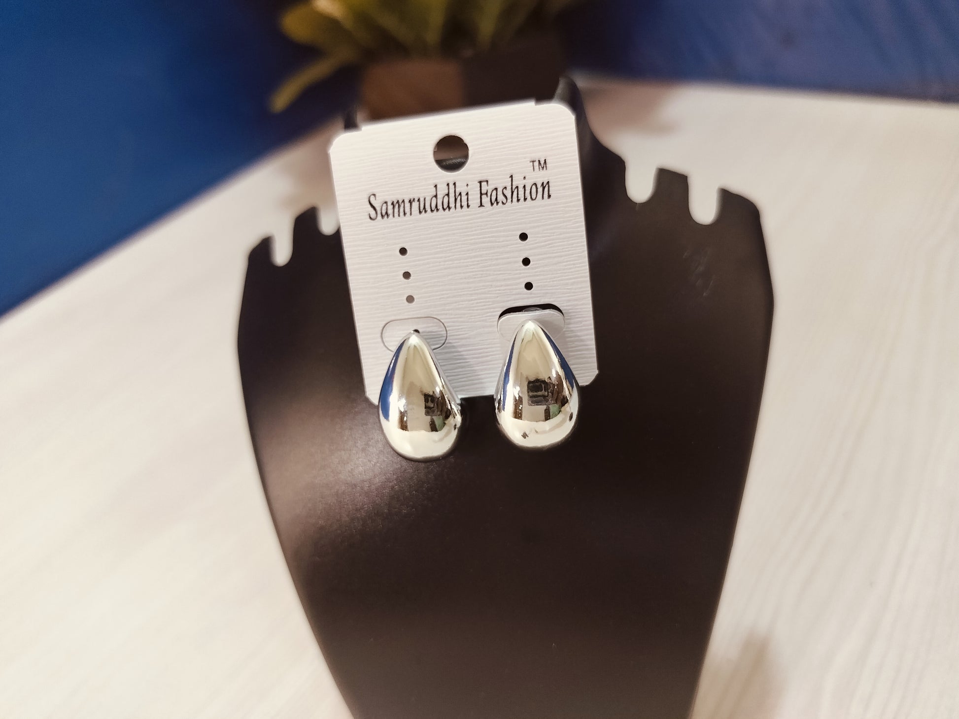 Wincham Fashion House Korean silver hoop earrings displayed on black stand with smooth polished finish