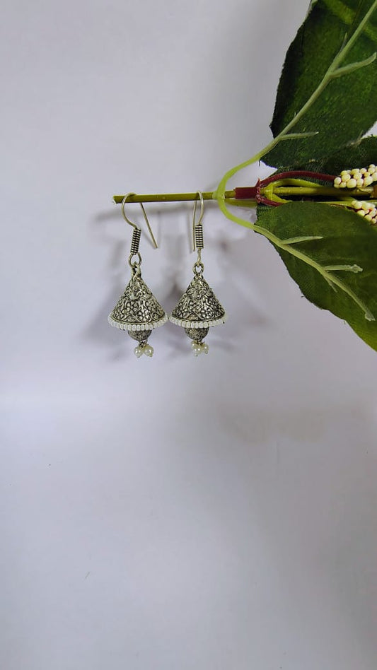Wincham Fashion House silver jhumki earrings with pearls hanging from a green branch