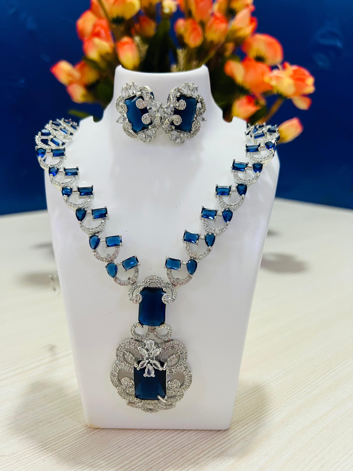 Elite royal blue design necklace set for weddings with silver detailing displayed on white stand