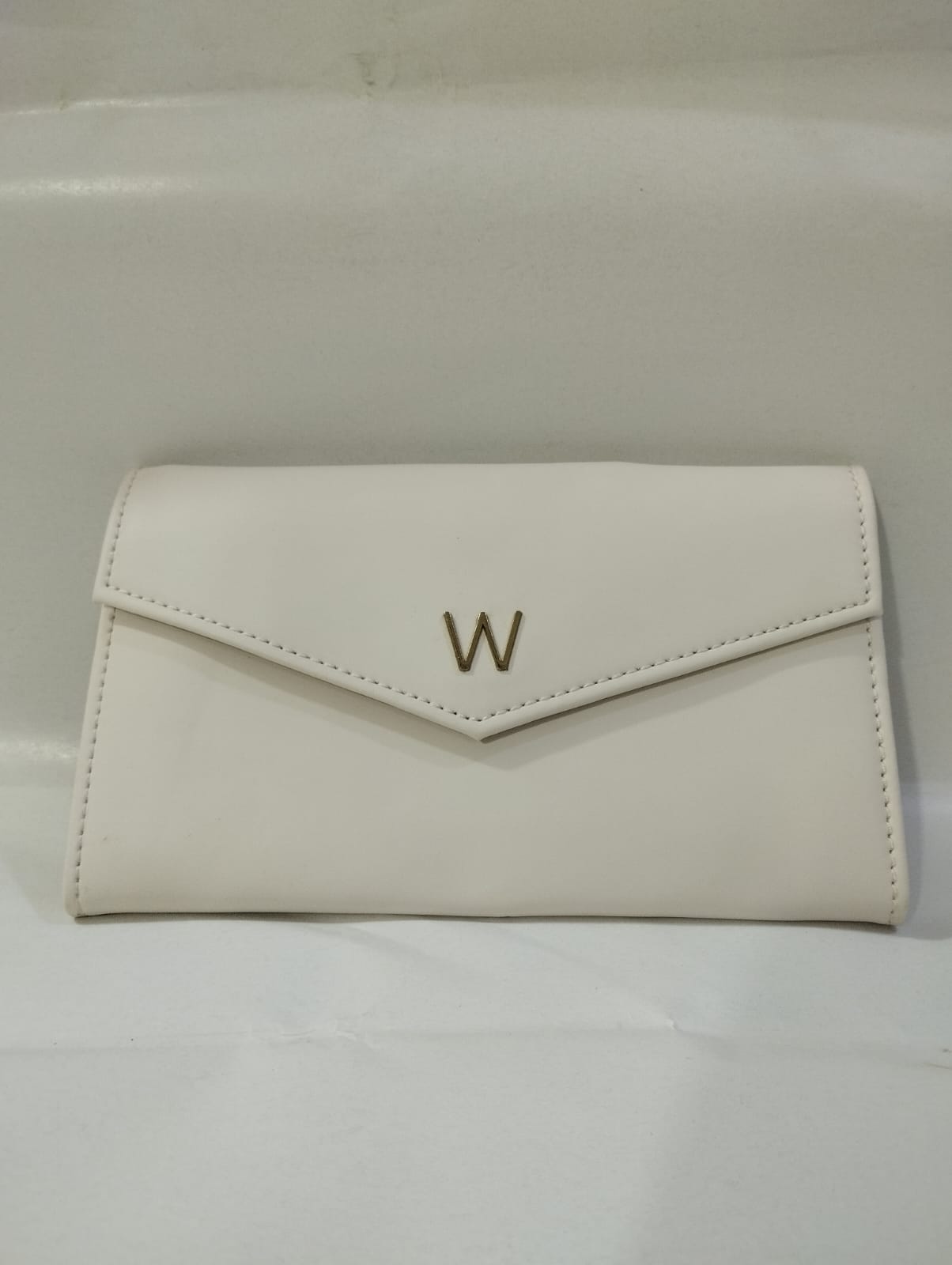 Elegant Wincham Fashion House small hand bag purse in white with a sleek design and gold logo