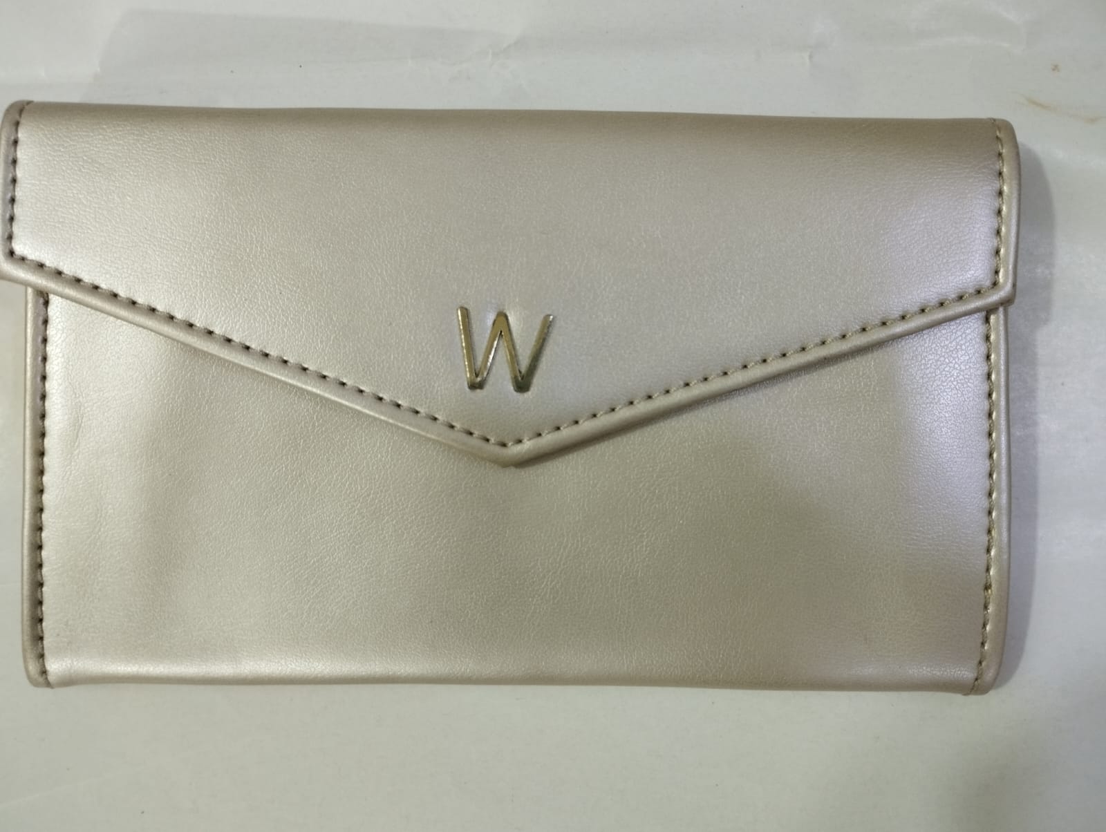 Elegant Wincham Fashion House small hand bag purse in metallic beige with a sleek envelope design