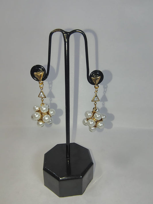 Elegant women with pearl earrings displayed on a black stand for a stylish accessory look